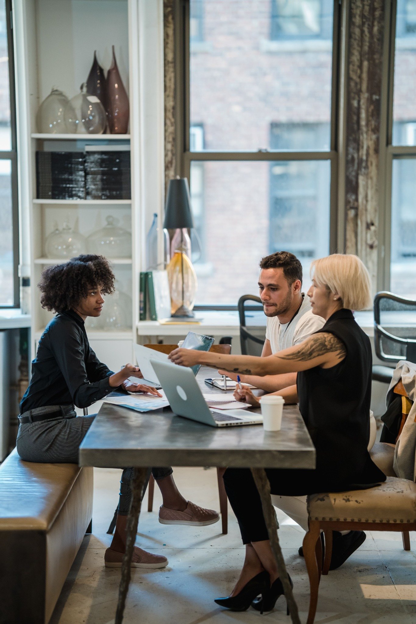 Three colleagues discussing their work around a table
